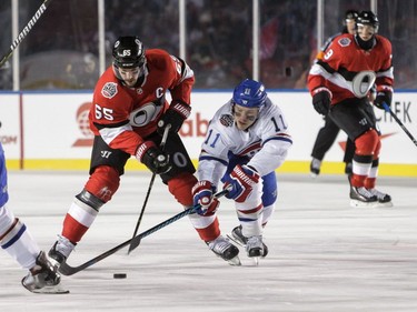 Erik Karlsson of the Ottawa Senators controls the puck against Brendan Gallagher of the Montreal Canadiens at the 2017 NHL 100 Classic at Lansdowne Park on Saturday, Dec. 16, 2017, in Ottawa.