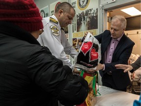 PQ leader Jean-François Lisée, right, and the SQ's Dany Dufour help with Sun Youth's food basket campaign in 2017.