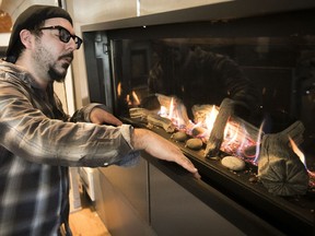 Poeles et Foyers Rosemont co-owner Charles Hamel gets a closer look at a gas fireplace — gas or propane stoves and fireplaces will be allowed when stricter burning laws are implemented in Montreal in fall 2018.