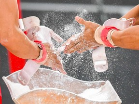 Gymnasts apply magnesia on their hands.