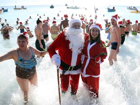 People dressed as Santa Claus take part in the traditional Christmas bath on December 17, 2017 in the French riviera city of Nice.