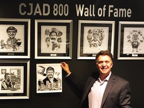 Broadcaster Andrew Carter holds up an Aislin caricature of recently retired CJAD host Tommy Schnurmacher, the latest addition to the radio station's Wall of Fame. Cartoons of previous inductees on the wall are from top left: George Balcan, Gord Sinclair, Ted Blackman, Dave Fisher and Paul Reid.