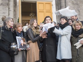 The children of Patrick Bourgeois, Penelope, Ludovick and Marie-William, release a dove as his wife Melanie Savard, left, looks on following funeral services for the singer of Les BB, a popular band at the end of the 1980s, Monday, Dec. 11, 2017 in Saint-Therese.