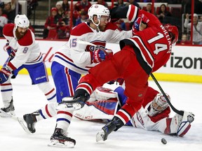 Montreal Canadiens' Joe Morrow (45) knocks Carolina Hurricanes' Justin Williams (14) off the puck in front of Canadiens goalie Carey Price (31) during the second period of an NHL hockey game, Wednesday, Dec. 27, 2017, in Raleigh, N.C.
