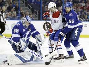 Montreal Canadiens center Jonathan Drouin (92) deflects the puck into Tampa Bay Lightning goalie Andrei Vasilevskiy (88), of Russia, as defenseman Braydon Coburn (55) defends during the first period of an NHL hockey game Thursday, Dec. 28, 2017, in Tampa, Fla.