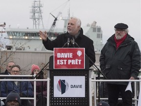 CSN union leader Yves Fortin, right, looks on as Quebec Premier Philippe Couillard, left, addresses hundreds of people at the end of a march of solidarity for the Davie shipyard, in Lévis on Sunday, Dec. 3, 2017.