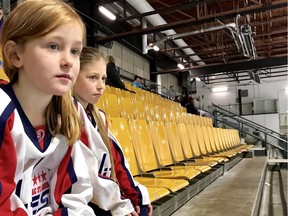 Romy Gravenor, left, and Virginie Jawich watch their friends play with the Lac St-Louis Élites at the Outremont arena. They have been denied permission to join the team.