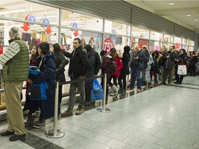 People wait in line outside a clothing store during Boxing Day sales in Montreal on Dec. 26.