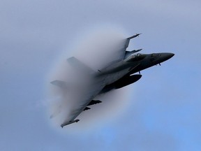 A F18 Super Hornet creates a vapor cone as it flies at a transonic speed in 2015.