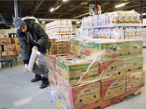 Artem Mousessian wraps a shipment for delivery at the distribution centre for Moisson Montréal, the largest food bank in Canada. Moisson Montréal is holding its traditional Christmas Harvest event to sort and fill holiday baskets on Dec. 16, 2017