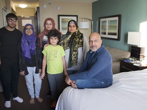 Tauseef Bhatti and wife Weena Sehar, second right, with children Bia, Aadn, Tuba and Minah pose in a hotel room in Montreal, Thursday, December 21, 2017. Bhatti and family have been staying at this hotel for months ever since their home was flooded in spring.