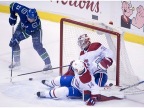 Canucks' Daniel Sedin  sends a shot past Canadiens' Tomas Plekanec and goalie Carey Price during second period Tuesday night in Vancouver. "Defensively we have to  be better," head coach Claude Julien says.