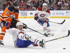 Canadiens' Andrew Shaw is tripped up by Oilers' Jujhar Khaira in Edmonton Saturday night, while Habs' Phillip Danault looks on.