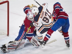 Edmonton Oilers' Connor McDavid (97) moves in on Canadiens goaltender Antti Niemi as Canadiens' Byron Froese defends during second period NHL hockey action in Montreal, Saturday, Dec. 9, 2017.
