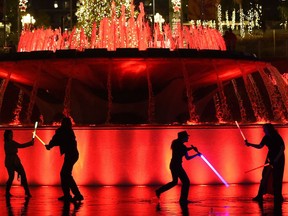 "Star Wars" fans battle each other with glowing sabers in a fountain at Grand Park during The Glow Battle Tour stop on Friday, Dec. 15, 2017, in Los Angeles.