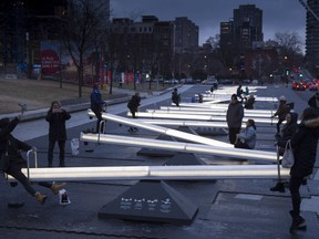 People play on a series of 30 interactive seesaws with light and sound that changes when in motion at the Place des Festivals Friday, December 8, 2017 in Montreal. "If the Bonjour-Hi affair has a silver lining, it is that irrational language spats seem more obsolete than ever," Dan Delmar writes.
