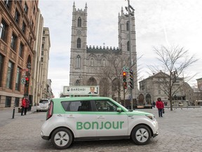 A taxi with Bonjour on the side drives past the Notre-Dame Basilica in Montreal on Thursday, November 30, 2017. The National Assembly is formally asking Quebec's merchants to "warmly" greet their clients with the word "Bonjour," and drop the old standard "Bonjour-hi."