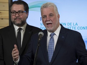 Quebec Premier Philippe Couillard speaks at a news conference at the end of a forum on diversity and anti-discrimination, Tuesday, December 5, 2017 in Quebec City. Quebec Immigration, Diversity and Inclusiveness Minister David Heurtel, left, looks on.