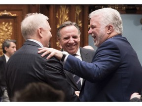 Quebec Premier Philippe Couillard, right, Parti Quebecois Leader Jean-Francois Lisee, left, and Coalition Avenir Quebec Leader Francois Legault, centre, exchange seasons greetings at the en of the fall session at the legislature in Quebec City on Friday, December 8, 2017.