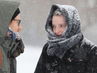 Véronique Trottier's scarf is covered in snow as she waits for a bus on Lakeshore Rd. in Dorval with friend Christophe Gagner Dec. 12, 2017.