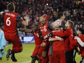 The Toronto FC celebrate a goal by midfielder Victor Vazquez (obscured) in stoppage time against the Seattle Sounders during second half MLS Cup Final soccer action in Toronto on Saturday, Dec. 9, 2017.