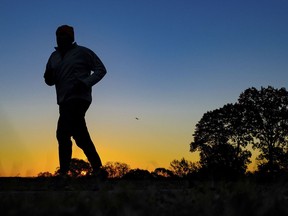 2016 file photo: A runner is silhouetted against the sunrise on his early morning workout