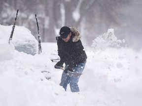 A man shovels snow from around his car following a winter storm in Montreal, Wednesday, March 15, 2017. Chiropractors saw an increase in the number of clinic visits this week as the first major snowfall of the season hit Montreal.