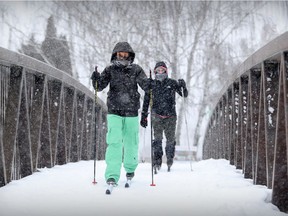 Karine Gingras, left, and Jean-Marc Cote ski over a bridge spanning the Petit Canal in Lachine Jan. 2, 2018.