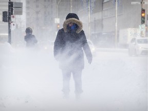 A woman is hit by a blast of blowing snow as she heads west on Rene-Levesque Blvd. in downtown Montreal Jan. 5, 2018.