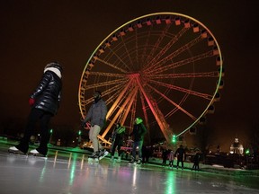 People enjoy a break in the cold and skate in the shadow of La Grande Roue in the Old Port of Montreal on Tuesday January 9, 2018.