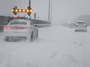 A Sûreté du Québec patrol car slows down traffic on the westbound Metropolitain on Saturday, January 13, 2018.