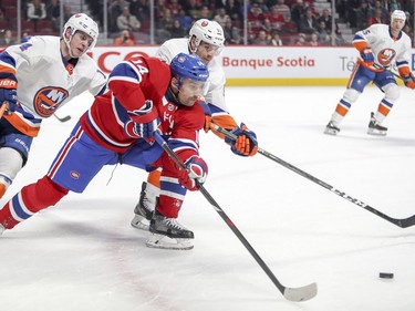 Montreal Canadiens Tomas Plekanec battles for loose puck with N.Y. Islanders Thomas Hickey, left, and John Tavares during first period of National Hockey League game in Montreal Monday Jan. 15, 2018.