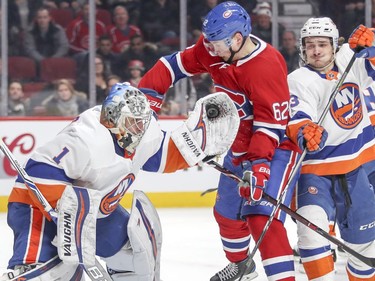 Montreal Canadiens Artturi Lehkonen looks for rebound as N.Y. Islanders goalie Thomas Greiss makes a trapper save during third period of National Hockey League game in Montreal Monday Jan. 15, 2018.  Islanders Mathew Barzal provides support at right.
