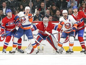 Montreal Canadiens goalie Carey Price follows the play in the middle of teammates Karl Alzner, left and Jeff Petry, right, while, N.Y. Islanders Jason Chimera and Cal Cluttebuck, second from right, try to provide screens during first period of National Hockey League game in Montreal Monday Jan. 15, 2018.