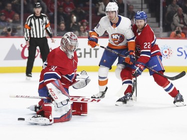 Montreal Canadiens Carey Price kicks the puck aside as teammate Karl Alzner checks N.Y. Islanders Brock Nelson during second period of National Hockey League game in Montreal Monday Jan. 15, 2018.