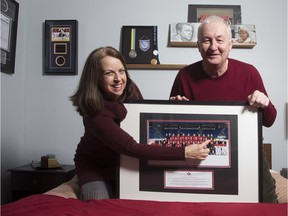 Francoise Bisutti and her husband Vittorio Gragnani, point out their son, from his team photo while playing for the Canadian National Men's Team at the 2011 Men's World Championship, at their home in IÎe-Bizard.