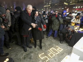 Montreal Mayor Vaérie Plante and Parti Québécois Leader Jean-Francois Lisée stop at a memorial set up in Place Émilie-Gamelin at vigil for Father Emmett "Pops" Johns in Montreal on Wednesday.