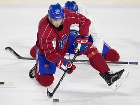 Laval Rocket centre Markus Eisenschmid passes a puck around the stretching circle after a team practice in Montreal on Wednesday, Jan. 17, 2018.