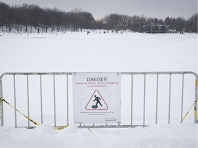 Signs warn pedestrians to stay clear of the ice on Beaver Lake on Thursday, Jan. 18, 2018.