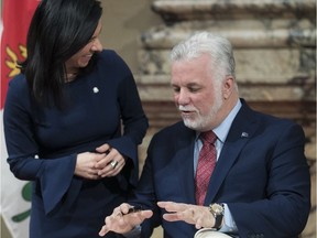 Quebec Premier Phillippe Couillard tells Montreal Mayor Valérie Plante what he wrote in the city's Golden Book during ceremony at Montreal city hall on Thursday, Jan. 18, 2018.