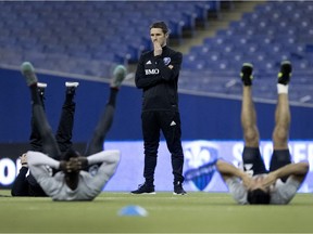 Montreal Impact head coach Rémi Garde watches as the team stretches during a team practice at Olympic Stadium in Montreal on Tuesday, January 23, 2018.