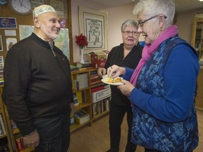 Imam Mehmet Deger (left) speaks with Nancy Mark (centre) and Sinclair Harris of the the Summerlea Refugee Support Coalition committee at the Dorval Mosque after an interfaith service on Sunday, to mark the first anniversary of the Quebec City mosque killings, which left six men dead and 19 people injured last year.