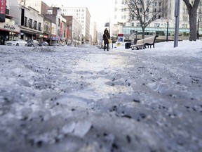 A pedestrian makes her way along the icy sidewalk on Peel St. on Wednesday, Jan. 31, 2018.