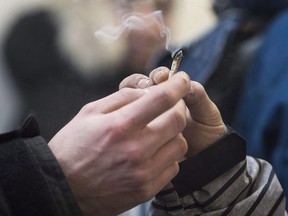 Two men pass a marijuana joint at Cannabis Culture in Montreal in a December 16, 2016