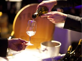 A sommelier pours a glass of white wine.