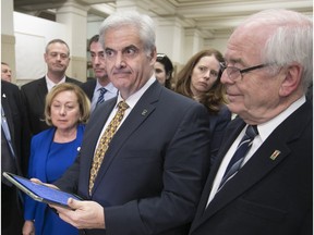 Montreal West Mayor Beny Masella (centre), Beaconsfield Mayor Georges Bourelle (right) and other suburban mayors speak to reporters after the agglomeration council approved a budget increasing contributions by independent municipalities on the island of Montreal by an average of 5.3 per cent on Jan. 25, 2018.