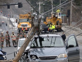 A utility pole with a transformer rests on top of a minivan after a three-car accident in this U.S. file photo. If you find yourself in a situation like this, stay in the vehicle until help arrives.