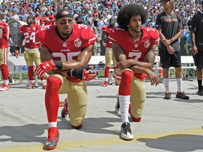 San Francisco 49ers' Colin Kaepernick (right) and Eric Reid kneel during the national anthem before a NFL football game against the Carolina Panthers in Charlotte, N.C., on Sept. 18, 2016.