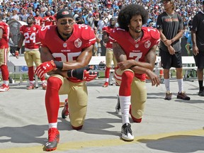 San Francisco 49ers' Colin Kaepernick (7) and Eric Reid (35) kneel during the national anthem before an NFL football game against the Carolina Panthers in Charlotte, N.C., Sunday, Sept. 18, 2016.