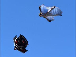 Two men fly in wingsuits.